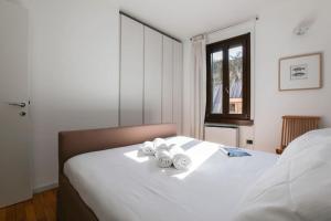 a bedroom with a bed with three rolled towels on it at HACCA Collection - Brera & Fashion District - Bright 2BR Apt in Milan