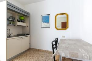 a kitchen and dining room with a table and a mirror at Luxemburg in Caorle +13 photos