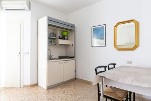 a kitchen and dining room with a table and a mirror at Luxemburg in Caorle