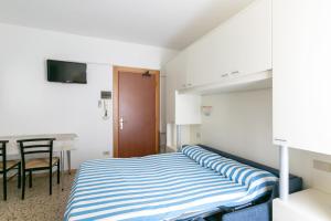 a small bedroom with a bed and a table at Luxemburg in Caorle