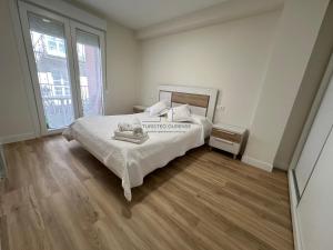 1 dormitorio con 1 cama y suelo de madera en O balcón de Santo Domingo en Ourense