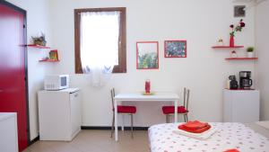 a white room with a table and a table and a microwave at The Relax Apartment - Le Cà De Boron in Montagnana