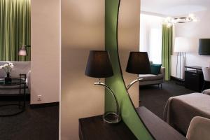 two pictures of a hotel room with a room with a bed and a mirror at Hotel Atrium in Krakow