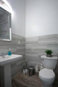 a bathroom with a white toilet and a sink at 5 BR - Sleeps 8! Steps from Bourbon Street! in New Orleans
