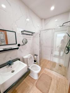 een badkamer met een wastafel, een toilet en een douche bij The Estretto Resort in Chiang Rai