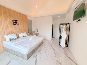 een slaapkamer met een groot bed en een marmeren vloer bij The Estretto Resort in Chiang Rai