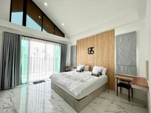 een slaapkamer met een groot bed en een groot raam bij The Estretto Resort in Chiang Rai