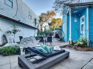 a patio with a couch and a table in front of a house at 5 BR - Sleeps 8! Steps from Bourbon Street! in New Orleans
