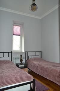 a bedroom with two beds and a window at Sunny Lodge Dilijan in Dilijan