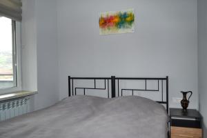 een slaapkamer met een bed en een schilderij aan de muur bij Sunny Lodge Dilijan in Dilidzjan