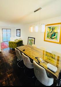 弗朗斯地區特朗布萊的住宿－VILLA LINDA，一间带木桌和椅子的用餐室