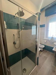 een badkamer met een glazen douche en een toilet bij Relax2 in Il Romito