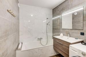 uma casa de banho com uma banheira, um lavatório e um chuveiro em White Pearl A03 - Alpes Travel - Central Chamonix - Sleeps 2-4 em Chamonix-Mont-Blanc
