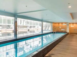 a large swimming pool in a building with windows at Wynyard Viaduct Habour 2 brm 2 bath and carpark in Auckland
