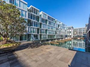 a large apartment building with a body of water at Wynyard Viaduct Habour 2 brm 2 bath and carpark in Auckland