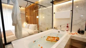 a bathroom with a bath tub and a bed at Mini luxury suites by Sea&theCity in Thessaloniki