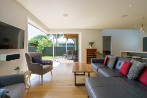 a living room with a couch and chairs and a table at Executive home in Mt Eden in Auckland