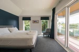 a bedroom with a large bed and a balcony at Executive home in Mt Eden in Auckland