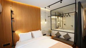 a bedroom with a bed and a tub and a mirror at Mini luxury suites by Sea&theCity in Thessaloniki