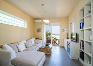 a living room with a white couch and a tv at The Seaside Villa in Chania Town