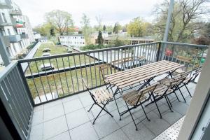 balcón con mesa y sillas de madera en Central Apartment 4 Bedrooms for up to 12 Guests, en Hamburgo