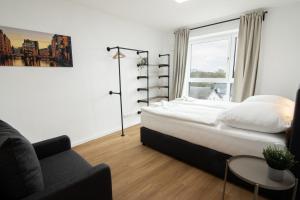 a bedroom with a bed and a couch and a window at Central Apartment 4 Bedrooms for up to 12 Guests in Hamburg