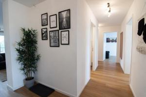 un pasillo con una pared blanca con cuadros. en Central Apartment 4 Bedrooms for up to 12 Guests, en Hamburgo