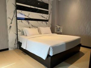 1 dormitorio con 1 cama grande con sábanas blancas en Sky dome resotel, en Bangkok