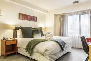 um quarto com uma cama com um urso de peluche em Lovely studio room in Citylife Hotel em Auckland