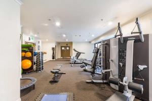 a gym with treadmills and machines in a room at Lovely studio room in Citylife Hotel in Auckland