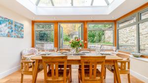 uma sala de jantar com mesa, cadeiras e janelas em Rowan Cottage - Carsington Water View 