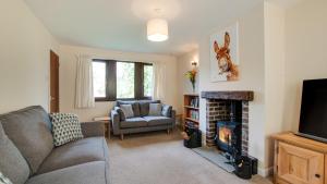 uma sala de estar com um sofá e uma lareira em The Catlow em Parwich