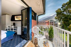 Un balcón de una habitación de hotel con una cama y una cama y un avisor en Bike & Wind Hotel Villa Maria - Happy Rentals en Nago-Torbole