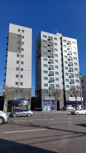 two tall buildings with cars parked in a parking lot at 서울아파트 3룸 4베드 Adi Stay in Seoul