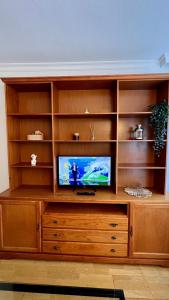 a large wooden entertainment center with a television on it at Ole Madrid Holiday Apartament IFEMA, Aeropuerto in Madrid