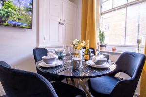 een eettafel met blauwe stoelen en een tafel en een raam bij Chic Urban Retreat 1 Bedroom Gem in Covent Garden 3AB in Londen