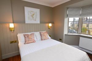 a bedroom with a white bed with two pillows at Urban Nest Townhouse in Galway