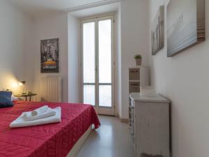 a bedroom with a red bed and a window at Lovely Home Apartment in Lecco