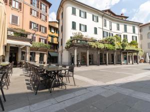an empty street with tables and chairs and buildings at Lovely Home Apartment in Lecco
