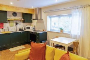 a living room with a yellow couch and a kitchen at Amarelo apartment, Central Charlbury, 1 Super king bed in Charlbury