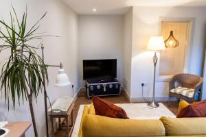 a living room with a yellow couch and a television at Amarelo apartment, Central Charlbury, 1 Super king bed in Charlbury