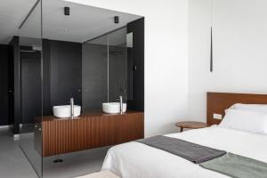 a bedroom with a bed and two sinks in a mirror at Land of Alandroal in Évora