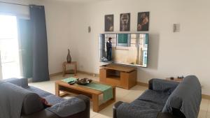 a living room with two couches and a large mirror at Apart Hotel Vila Verde in Santa Maria