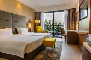 a hotel room with two beds and a table and chairs at Crowne Plaza Nairobi Airport by IHG in Nairobi