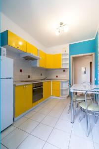 uma cozinha com armários amarelos e uma mesa com cadeiras em Kvartirkoff na Bogatirskaya 6a, 3 floor em Kiev