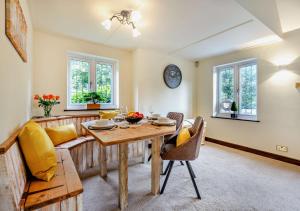 uma sala de estar com uma mesa e um sofá em Throop House Cottage - Bournemouth em Bournemouth