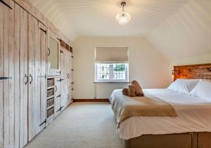 um quarto com uma cama grande e uma janela em Throop House Cottage - Bournemouth em Bournemouth