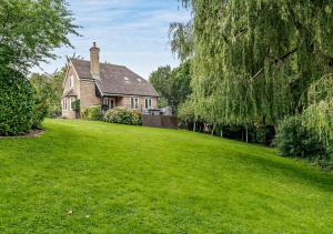 a house with a large lawn in front of it at Throop House Cottage - Bournemouth in Bournemouth