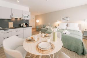 a room with a bed and a table with chairs at 5 Min Central 1 Room Apartment - Opera in Bayreuth