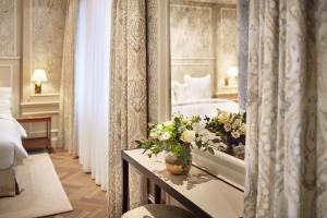 a hotel room with a bed and a table with flowers at Hotel Zur Wiener Staatsoper in Vienna